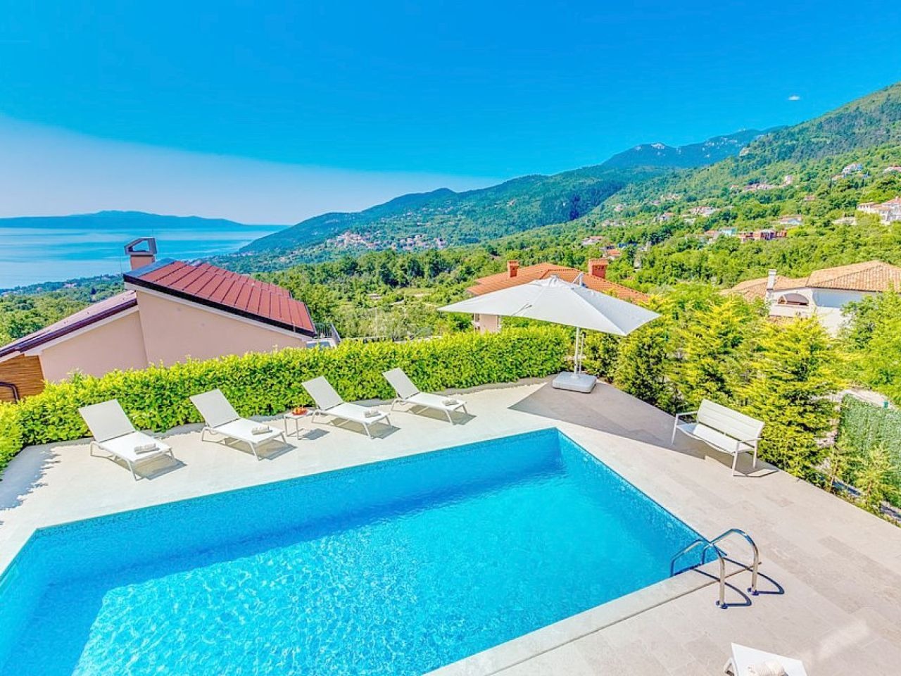 Pool terrace and green hillside setting