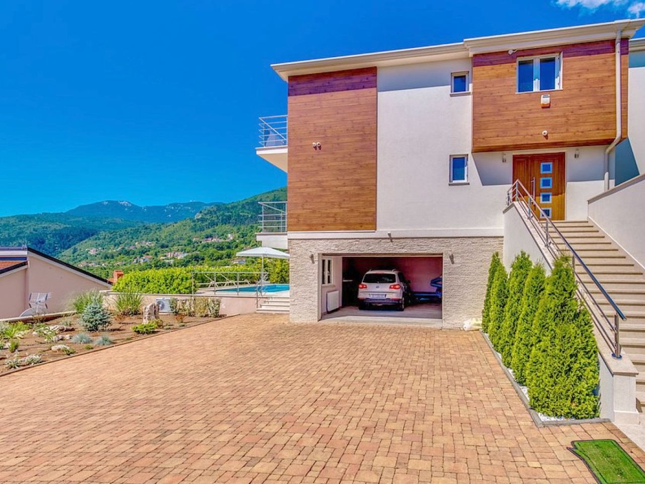 Villa entrance, paved driveway and garage