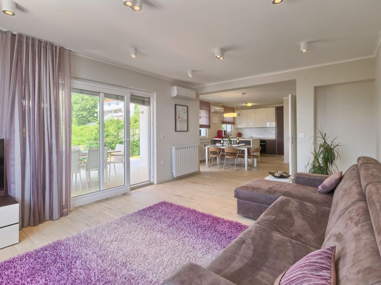 Open-plan living room, kitchen and dining area beside the patio