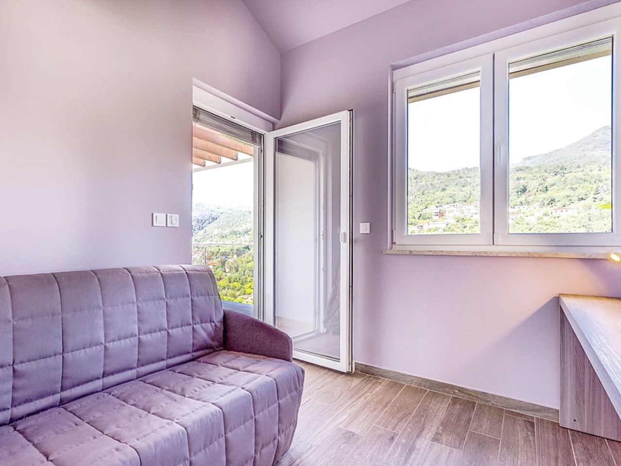 Upper-floor sitting room opening to a hillside-view terrace